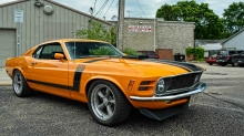 Вид со стороны на оранжевый Ford Mustang
